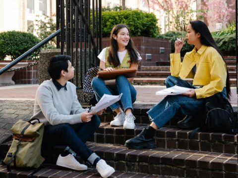 three students hanging out on college stairs